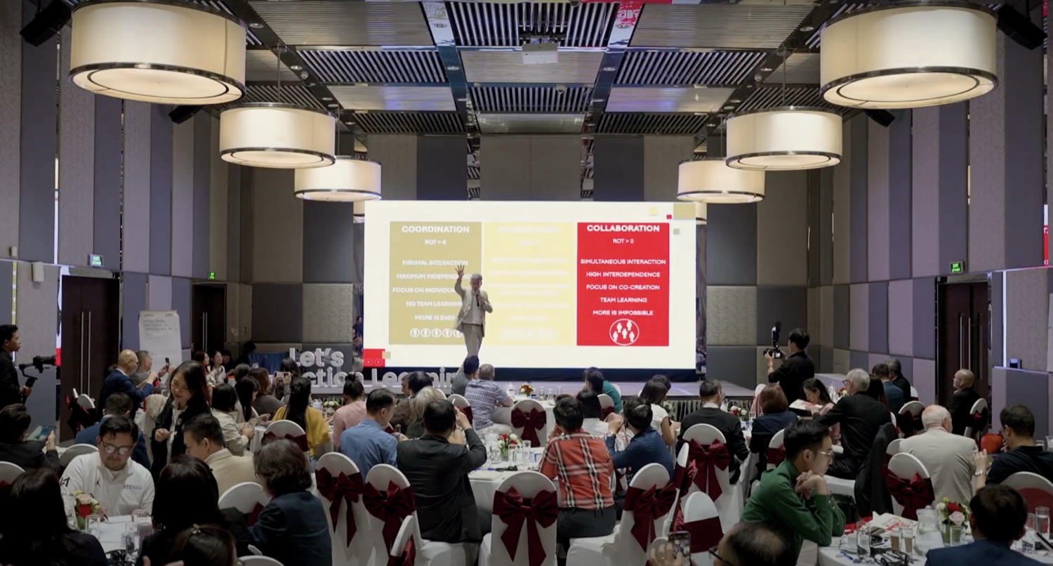 Peter Cauwelier delivering a keynote on stage to a large audience